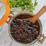 Hausgemachte schwarze Bohnensauce in einem Glas mit Holzlöffel, ideal für asiatische Gerichte und Dips.